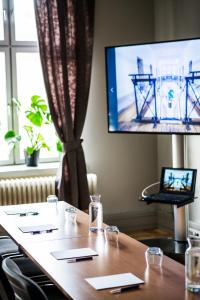 于默奧的住宿－格姆拉番格爾塞特酒店，一间会议室,配有桌子和电视