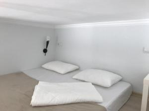 2 almohadas blancas en una cama en una habitación en Студия Париж в Александровском саду, en Adler