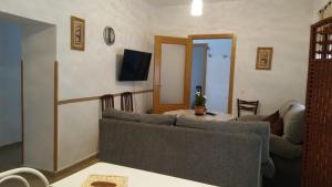ein Wohnzimmer mit einem Sofa und einem TV in der Unterkunft Casa Simona in Navas de Estena