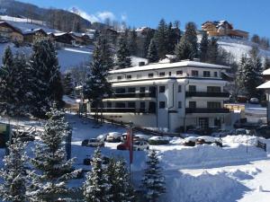 a large white building in the snow with cars parked at Appartement Traumblick by Schladming Appartements in Schladming