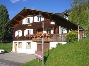 a house with a balcony with flowers on it at Studio Schija in Sankt Antönien