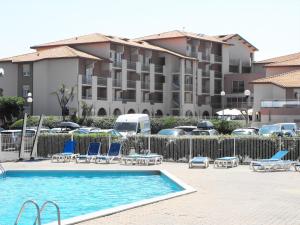 a swimming pool with lounge chairs and a building at Mer et Golf in Anglet