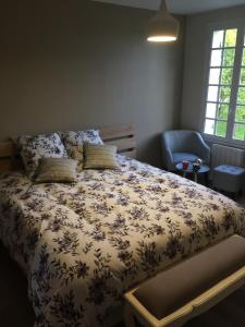 1 dormitorio con 1 cama y 1 silla en Chambres D'hôtes le clos de la Bertinière petit déjeuner inclus, en Bosgouet