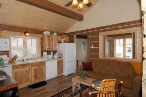 a living room with a couch and a kitchen at True Grit Adventure by KABINO Dogs OK FirePit Satellite WiFi Sleeper Sofa Perfect Location Rustic Modern in Island Park