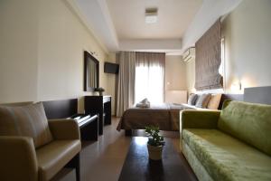 une chambre d'hôtel avec un lit et un canapé dans l'établissement Hotel Dionisos, à Leptokaryá