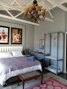 a bedroom with a bed and a chandelier at At Rest in Zeerust