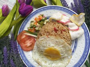 Hotel Banyuwangi Sintera في جاكرتا: طبق من الطعام مع البيض والأرز والخضروات