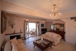 a living room with two couches and a chandelier at Captain's Gem in Sami