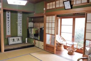 een kamer met een keuken met een magnetron en een raam bij Guest House Ilonggo in Tsu