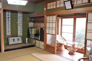 a room with a kitchen with a microwave and a window at Guest House Ilonggo in Tsu