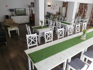 a living room with white tables and chairs with green mats at Willa Grafit in Karpacz