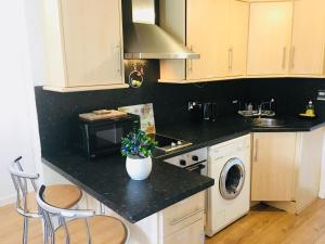 a kitchen with a counter with a vase of flowers on it at Private Studio Free Parking in Oxford