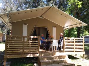 Cozes的住宿－樂索盧特營地酒店，两人坐在帐篷里的桌子上