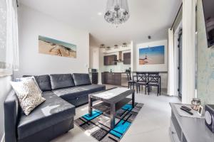 a living room with a couch and a table at Dwie Sosny z sauną, Sun & Snow in Ustronie Morskie