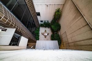 un pasillo de un edificio con plantas en la pared en Flat Premier 14 Max Savassi en Belo Horizonte