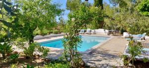 una piscina en un patio con sillas y árboles en Can Iara en Sant Miquel de Balansat