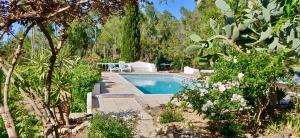 a swimming pool in a garden with trees at Can Iara in Sant Miquel de Balansat