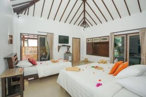 a bedroom with two beds and a couch at Martas Hotel in Gili Trawangan