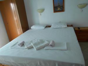 a large white bed with two towels on it at Haus Dusseldorf in Potos