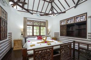 a bedroom with a bed in a room with windows at Martas Hotel in Gili Trawangan