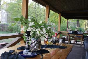 a vase of flowers on a table in a pavilion at Izbushka in Riga