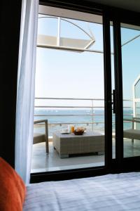 a bedroom with a view of the ocean through a glass door at Atlantic Hôtel & Spa in Les Sables-d'Olonne