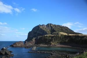 a view of a rocky island in the ocean at Sea Dragon Pension in Seogwipo