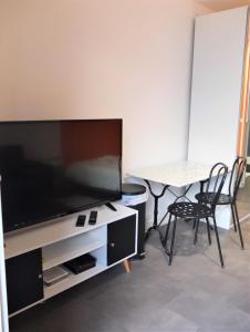 uma sala de estar com uma grande televisão e uma mesa em Studio tout équipé - 300m gare - 005 em Rouen