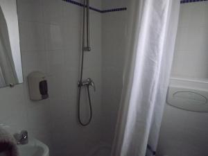 bagno con doccia e tenda doccia di Residencia Laranjeira a Odeceixe