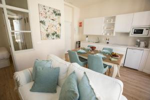 a living room with a white couch and a table at Gr Suites Boutique Catedral in Málaga