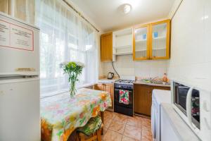 a kitchen with a table with a vase on it at Квартира эконом-класса возле метро Левобережная in Kyiv