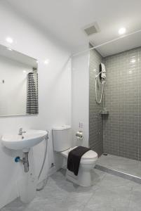 La salle de bains est pourvue de toilettes, d'un lavabo et d'une douche. dans l'établissement Minimal House Patong, à Patong Beach
