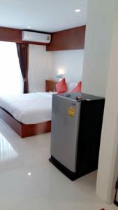 - une chambre avec un lit et un petit réfrigérateur dans l'établissement DEE DEE Mansion Airport, à Nai Yang Beach