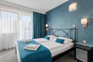 Schlafzimmer mit einem Bett mit blauer Wand in der Unterkunft Hotel Porec in Poreč