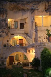 a large stone building with a staircase in front of it at Elkep Evi Cave Hotel in Ürgüp