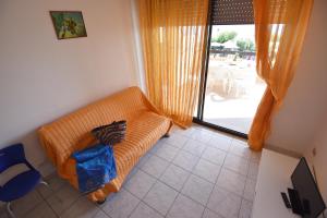 un sofá naranja en una habitación con vistas a un patio en Vistamare, en Silvi Marina