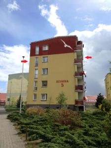 a building with two flags on the side of it at Apartament Nad Dziwną in Dziwnów