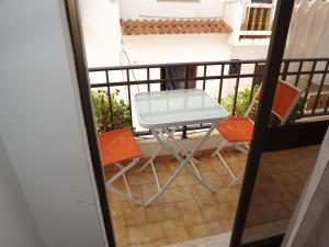 a table and two chairs on a balcony at Residencia Laranjeira in Odeceixe