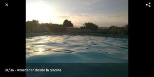 una piscina de agua con el sol en el fondo en La Bella Sombra, en Mareny Barraquetas