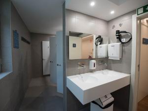 a bathroom with a white sink and a mirror at room00 Lisboa Hostel in Lisbon