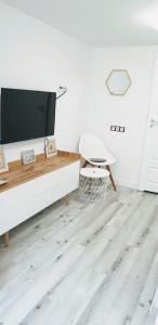 a living room with a tv and a wooden floor at Gaia Studio in Wrocław