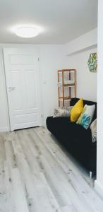 a living room with a black couch in front of a door at Gaia Studio in Wrocław