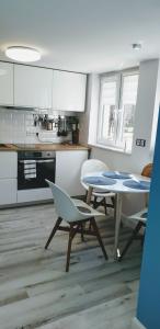 a kitchen with a table and chairs in a room at Gaia Studio in Wrocław