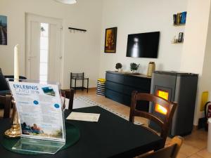 a living room with a table and a tv at Ferienhaus Villach in Villach