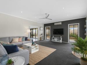 a living room with a couch and a tv at BEACHED AS - FREE WIFI, NETFLIX & FOXTEL in Inverloch