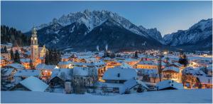 a city covered in snow with mountains in the background at Bergut Niggler - Rusticus in Dobbiaco