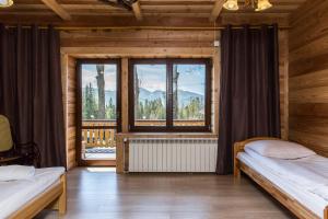 sypialnia z 2 łóżkami i dużym oknem w obiekcie udanypobyt Apartament Przy Lesie w mieście Kościelisko