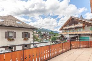 a balcony with a wooden fence and buildings at PLACE EGLISE 2 in Morzine