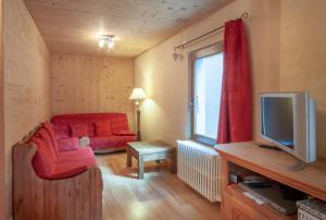 a living room with a red couch and a tv at PLACE EGLISE 2 in Morzine