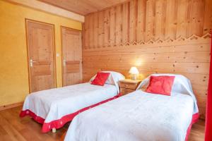 - 2 lits dans une chambre dotée de murs en bois dans l'établissement PLACE EGLISE 2, à Morzine